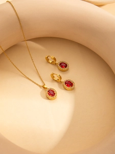 Detail von Luxus-Goldschmuckset mit ovalen Rubinedelsteinen und Zirkonia-Verzierung aus Titan