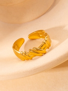 Artistic gold twisted titanium ring with a sculptural spiral design and satin finish