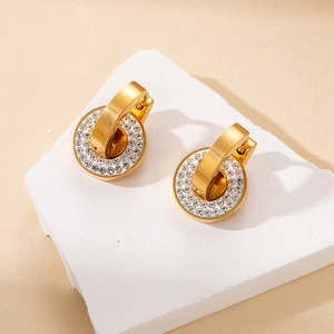 Detailed macro view of gold hoop earrings with sparkling crystal-encrusted round charms