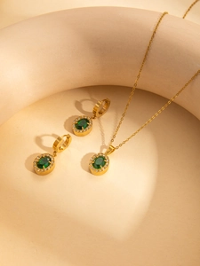 Detailansicht des vergoldeten Schmucksets mit smaragdgrünen Zirkonia und feinen Diamanten