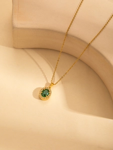 Detailansicht der Vintage-Goldkette mit ovalem grünem Edelstein und Zirkon-Halo