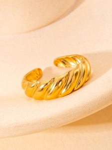 Macro shot of gold croissant dome ring with elegant twist design on a curved display