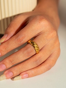 Macro view of gold plated croissant ring showing polished spiral texture and vintage finish