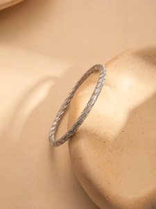 Detail showing diagonal textured engraving on a minimalist silver steel bracelet