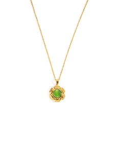 Detail van gouden titanium ketting met geometrische zonnestraal hanger en groene steen