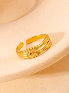 Detail of gold multi-layer twisted open ring with adjustable triple band design