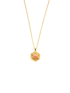Detailopname van een gouden titanium ketting met een ronde roodbruine edelsteen hanger