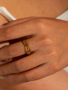 Macro detail of gold-plated twisted rope ring showcasing minimalist aesthetic