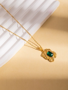 Detail van de vintage gouden titanium ketting met een smaragdgroene rechthoekige steen