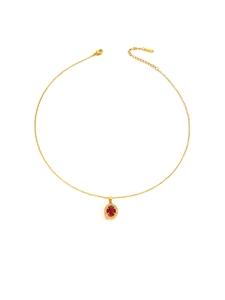 Detailaufnahme einer goldenen Titanstahlkette mit rotem ovalem Edelstein und Zirkonen