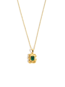 Detailopname van de smaragdgroene rechthoekige edelsteen hanger aan een gouden ketting