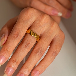 Golden titanium steel croissant ring with vintage twisted rope design on finger