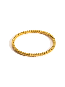 Detailed close-up of a minimalist 18K gold plated bangle with textured bead pattern