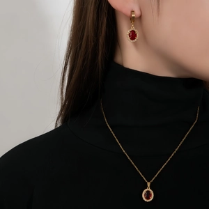 Elegantes vergoldetes Schmuckset mit ovalen roten Edelsteinen und weißen Zirkonia-Details