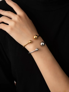 Polished titanium steel open bangles in gold and silver finish on person wrist