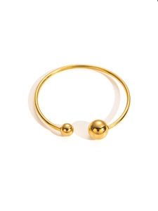 Close-up of golden geometric cuff bracelet featuring minimalist dual polished spheres