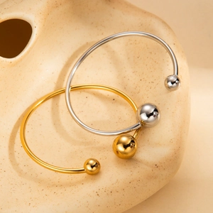 Polished titanium steel open bangles set in gold and silver finish with sphere ends