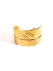 Close-up of golden feather texture on wide stainless steel cuff bracelet
