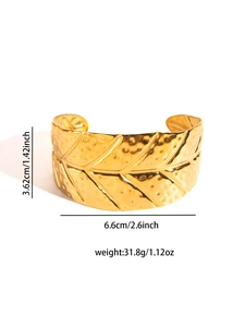 Detailed view of leaf texture and hammer pattern on wide gold plated steel cuff bracelet