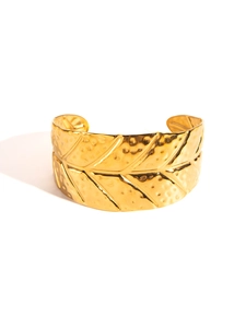 Macro detail of golden leaf-vein textured cuff bangle with hammered metal finish
