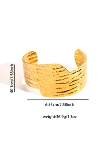 Detailed view of wide gold titanium steel cuff with hammered texture and dimensions
