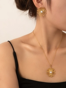 Close-up of elegant gold sunflower necklace and earrings set with white pearls