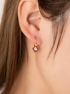 Close-up of vintage French earrings with red enamel and square zircon in 18K gold finish