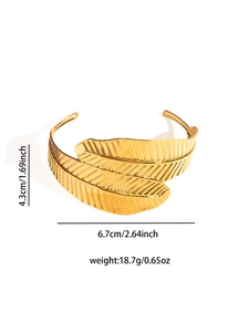Macro detail of golden leaf-shaped cuff bracelet with fine textures and dimensions