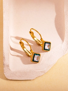 Detail of vintage 18K gold plated earrings with square zircon and green enamel accents