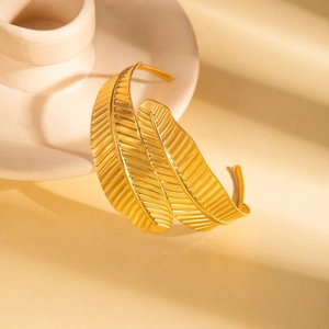 Golden titanium steel double leaf bangle with textured surface in soft lighting