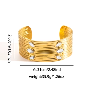 Dettaglio della trama a onde e cristalli su un bracciale a fascia dorato da 2,68 cm