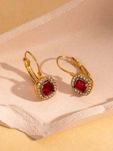 Detail view of vintage lever-back earrings with red square stones and crystal halo