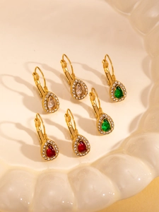 Detailed view of 18K gold teardrop earrings with emerald, ruby, and crystal stones