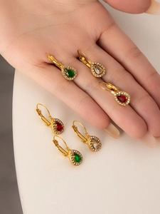 Detail of pear-cut earrings in red, green, and clear stones with gold lever-back design