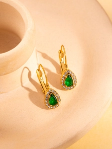 Detail of vintage 18K gold-plated lever-back earrings with green pear-shaped gemstones