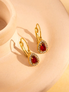 Detail of 18K gold plated teardrop earrings with red gemstone and micro-pave crystals