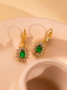 Detail of 18K gold plated vintage earrings with green oval stone and small crystals