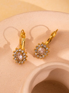 Macro detail of French retro gold earrings featuring an oval zircon cluster and lever back design