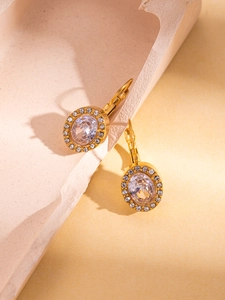 Detail of 18K gold plated oval earrings with halo zircon stones on rock pedestal