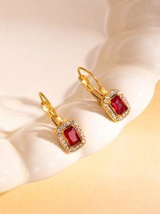 Detail of vintage 18K gold earrings with red rectangular stone and zircon halo
