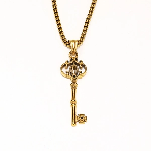 Detailed macro view of vintage gothic crown key pendant with box chain in gold finish