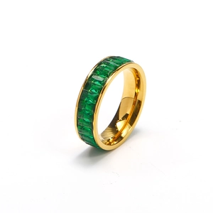 Close-up of gold eternity ring with emerald green rectangular cut zircon stones