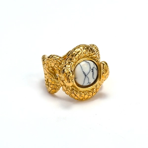 Detail view of gold snake ring featuring textured scales and a white turquoise stone inlay