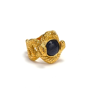 Detailed macro of gold snake ring with realistic scale texture and blue sandstone inlay