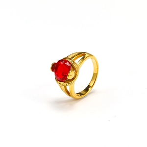 Detailed close-up of a vintage 18k gold ring featuring a large faceted round red gemstone