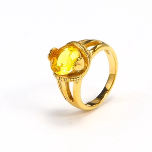 Detailed macro view of an 18k gold plated ring with a large faceted yellow gemstone
