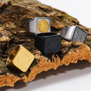 Men's vintage matte compass rings in silver, black and gold finishes on natural wood