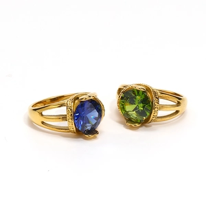 Detail of vintage gold plated rings featuring large round blue and green gemstones
