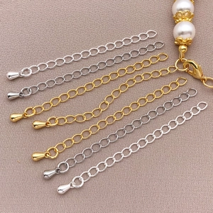 Detailed macro view of 18K gold and silver extender chains with pearl and lobster clasp