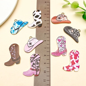 Détail de pendentifs émaillés chapeau et botte de cow-boy avec règle pour référence